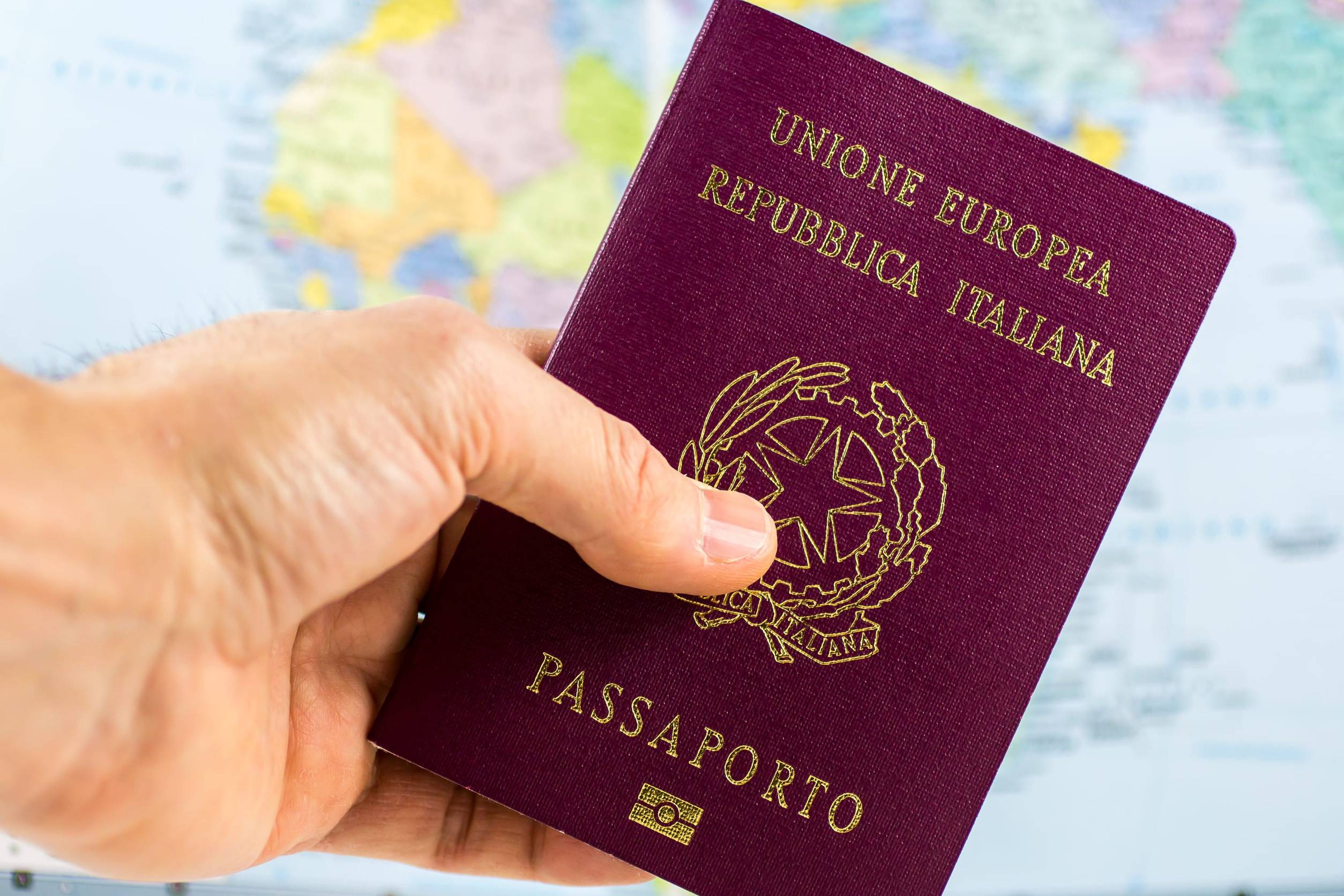 A Hand Holding An Italian Passport
