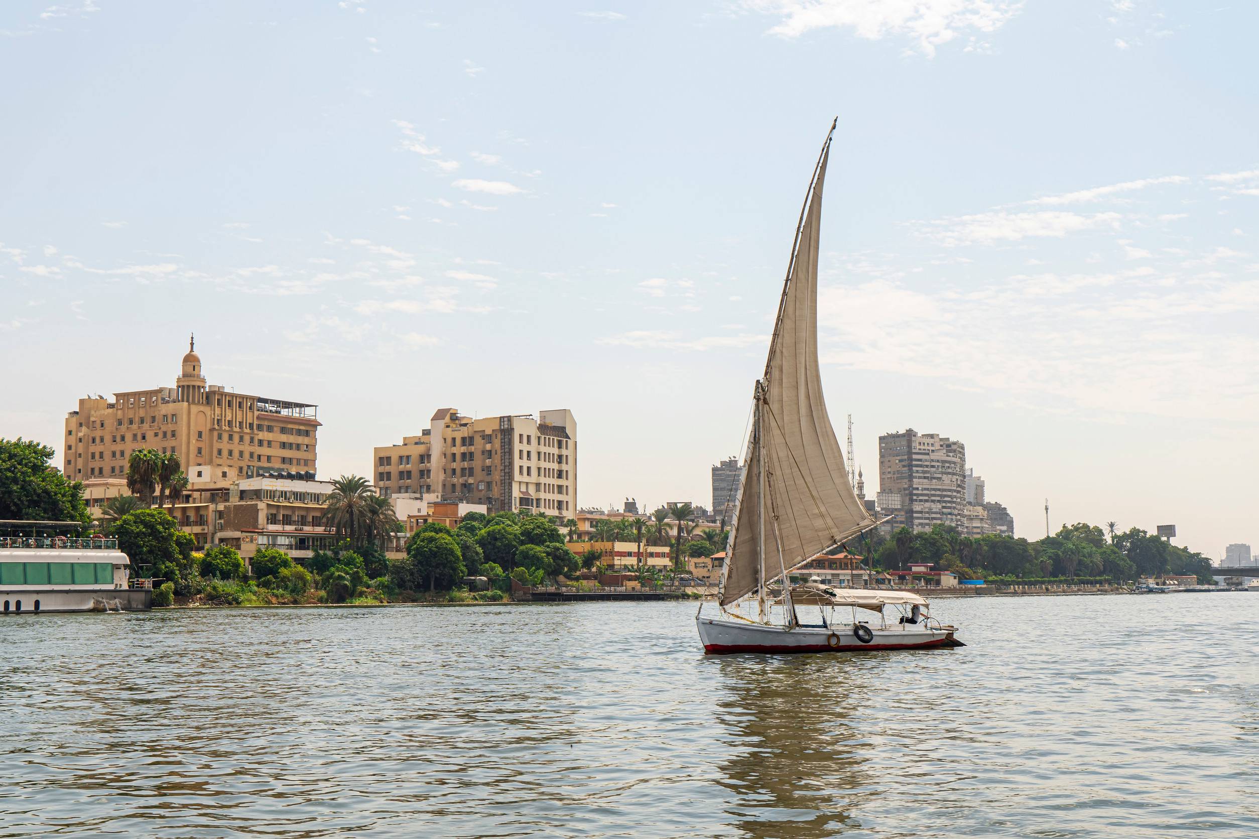 https egypt eta com images a sailboat on a river walk sails along the nile river in the center of cairo among the skyscr