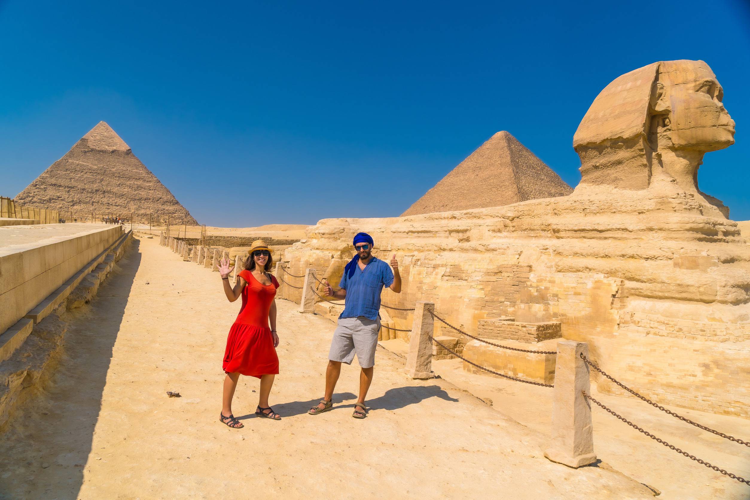 https egypt eta com images a tourist couple at the great sphinx of giza and in the background the pyramids of giza