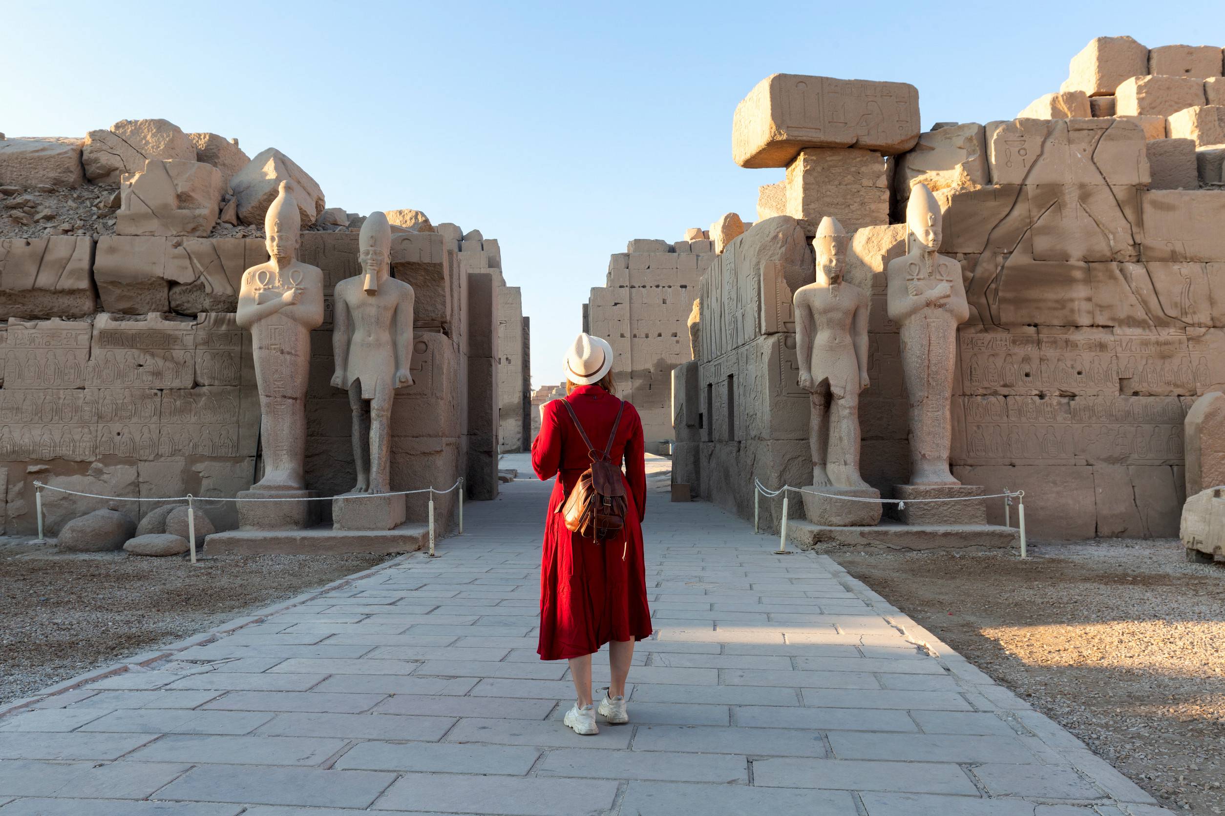https egypt eta com images a visitor in a red dress explores the ancient colonnade at the karnak temple in luxor