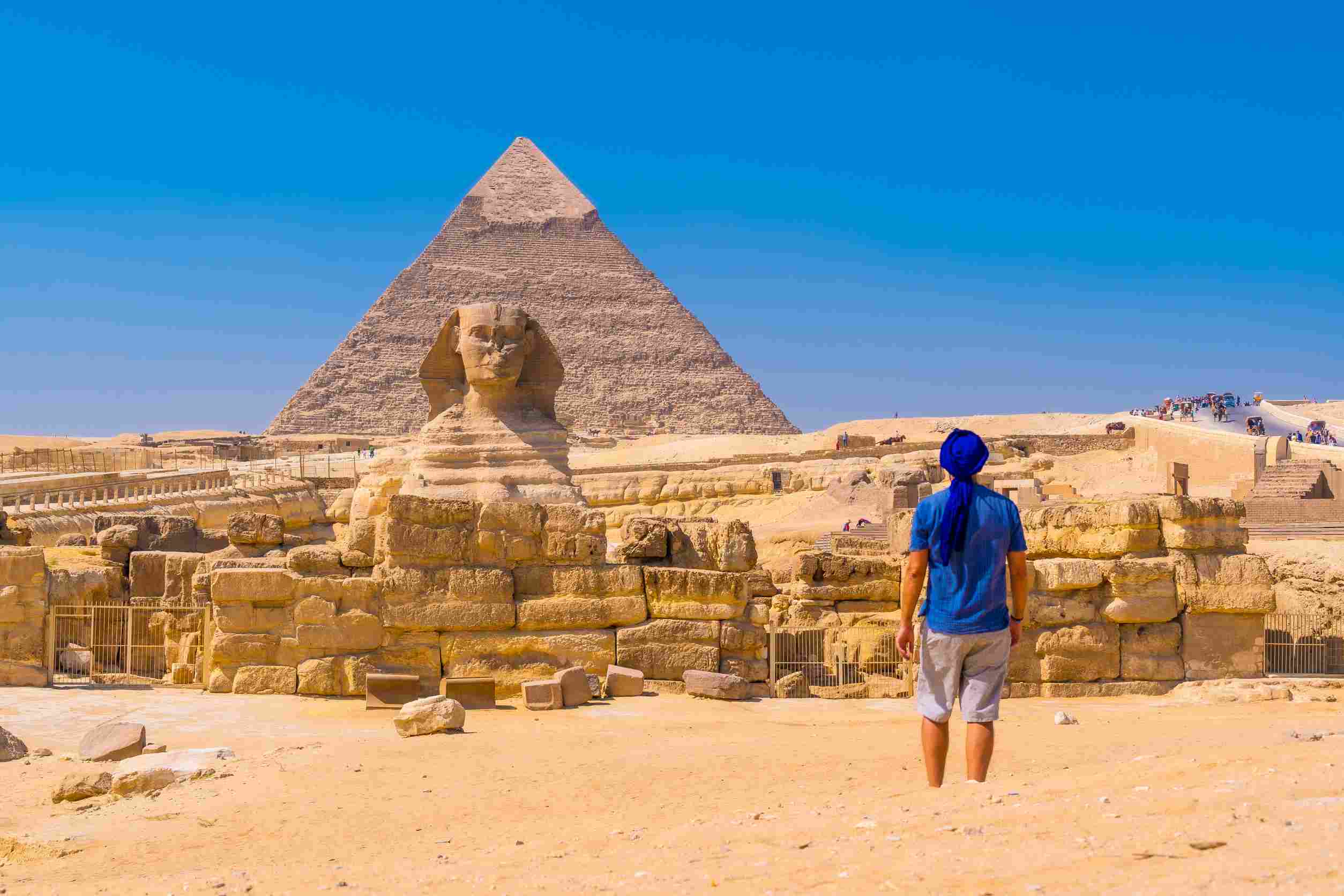 https egypt eta com images a young man walking towards the great sphinx of giza and in the background the pyramid of khafre