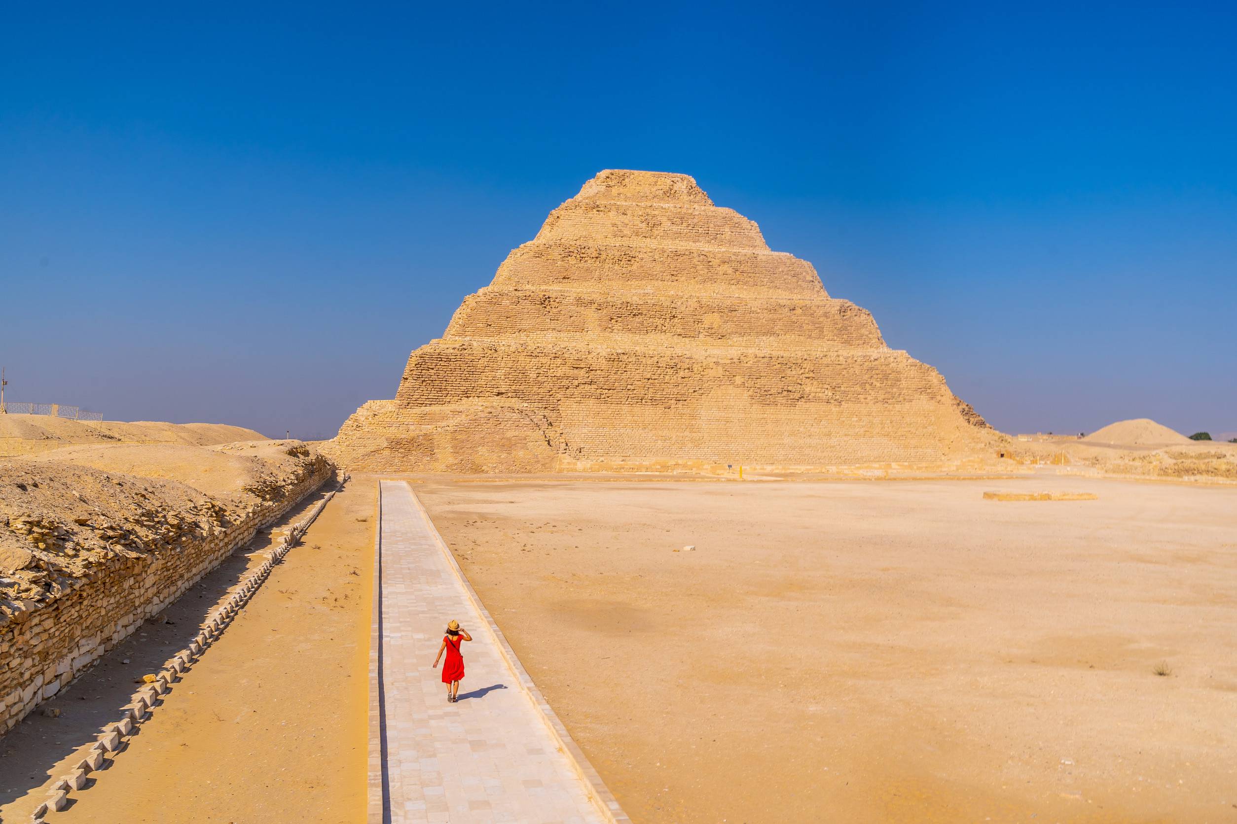 https egypt eta com images a young woman in a red dress visiting the stepped pyramid of djoser saqqara egypt