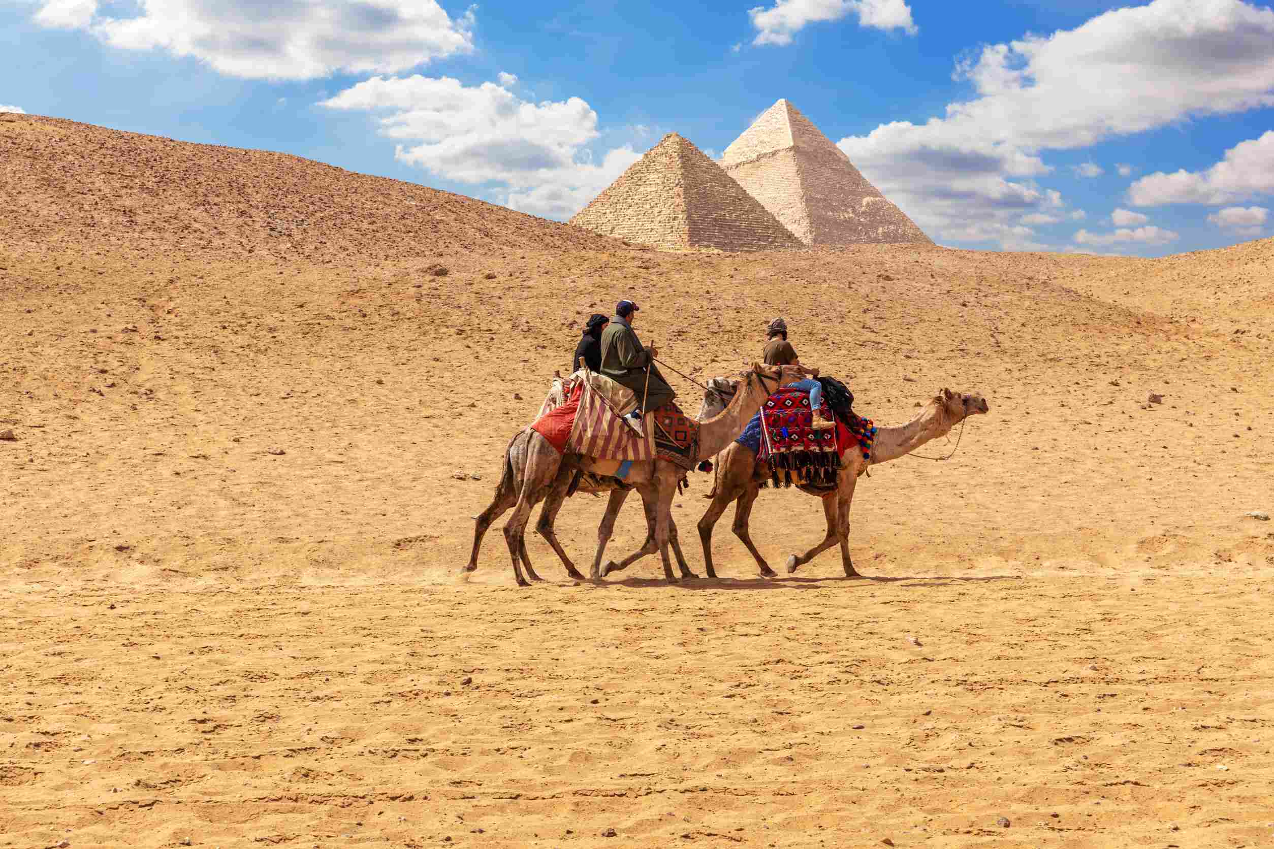 https egypt eta com images egyptian men on camels in the sands of giza near the pyramid