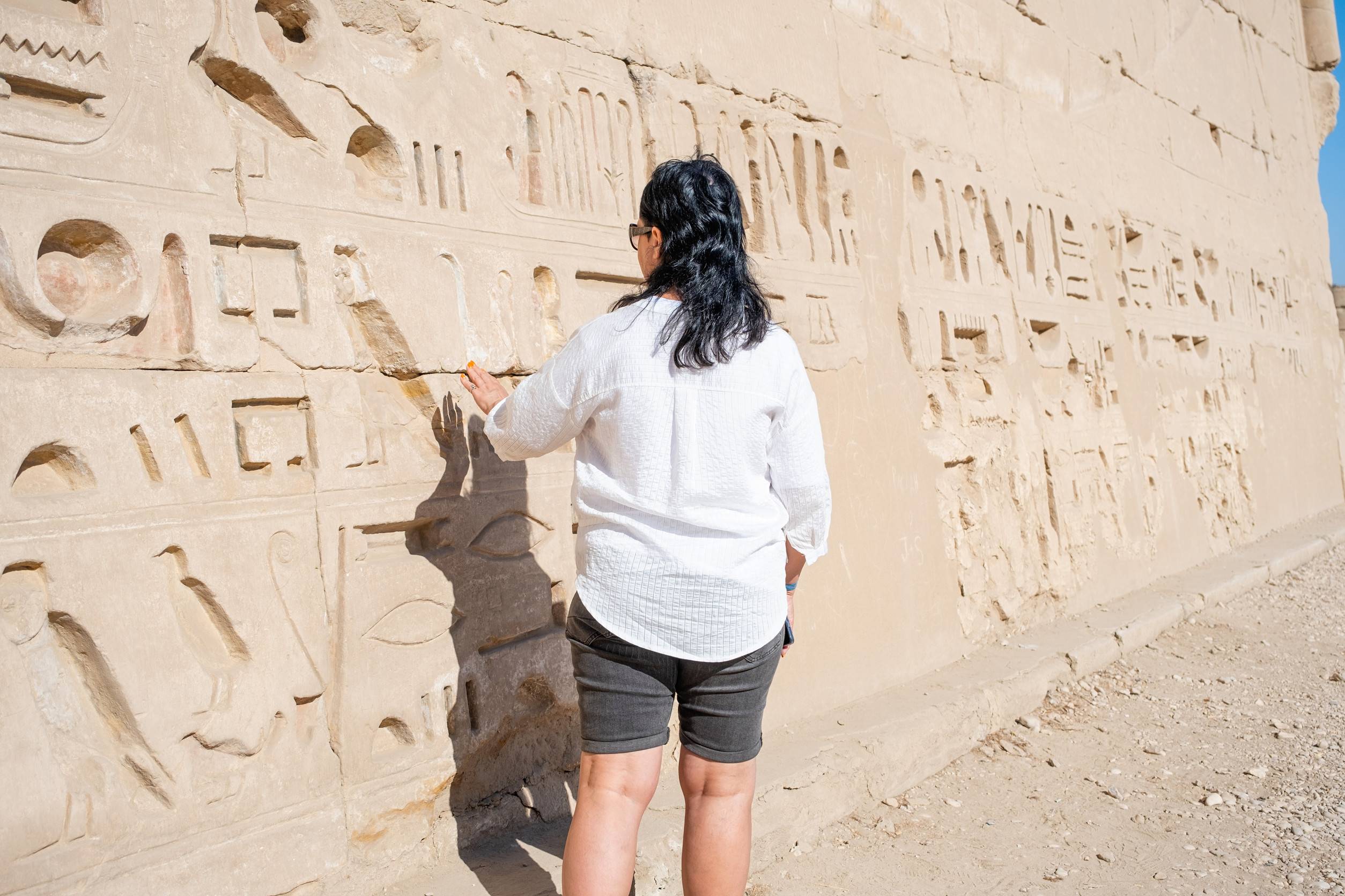 Mature Adult Woman Traveler Explores The Ruins Of The Ancient Karnak Temple In The City Of Luxor