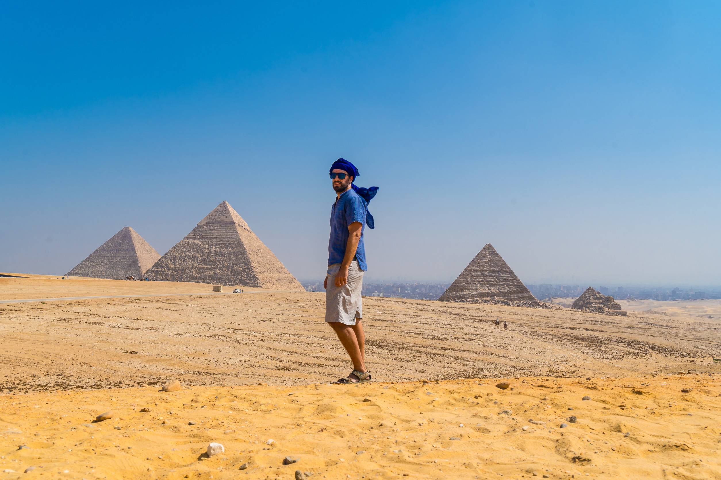 https egypt eta com images portrait of a young man in a blue turban walking next to the pyramids of giza the oldest funer