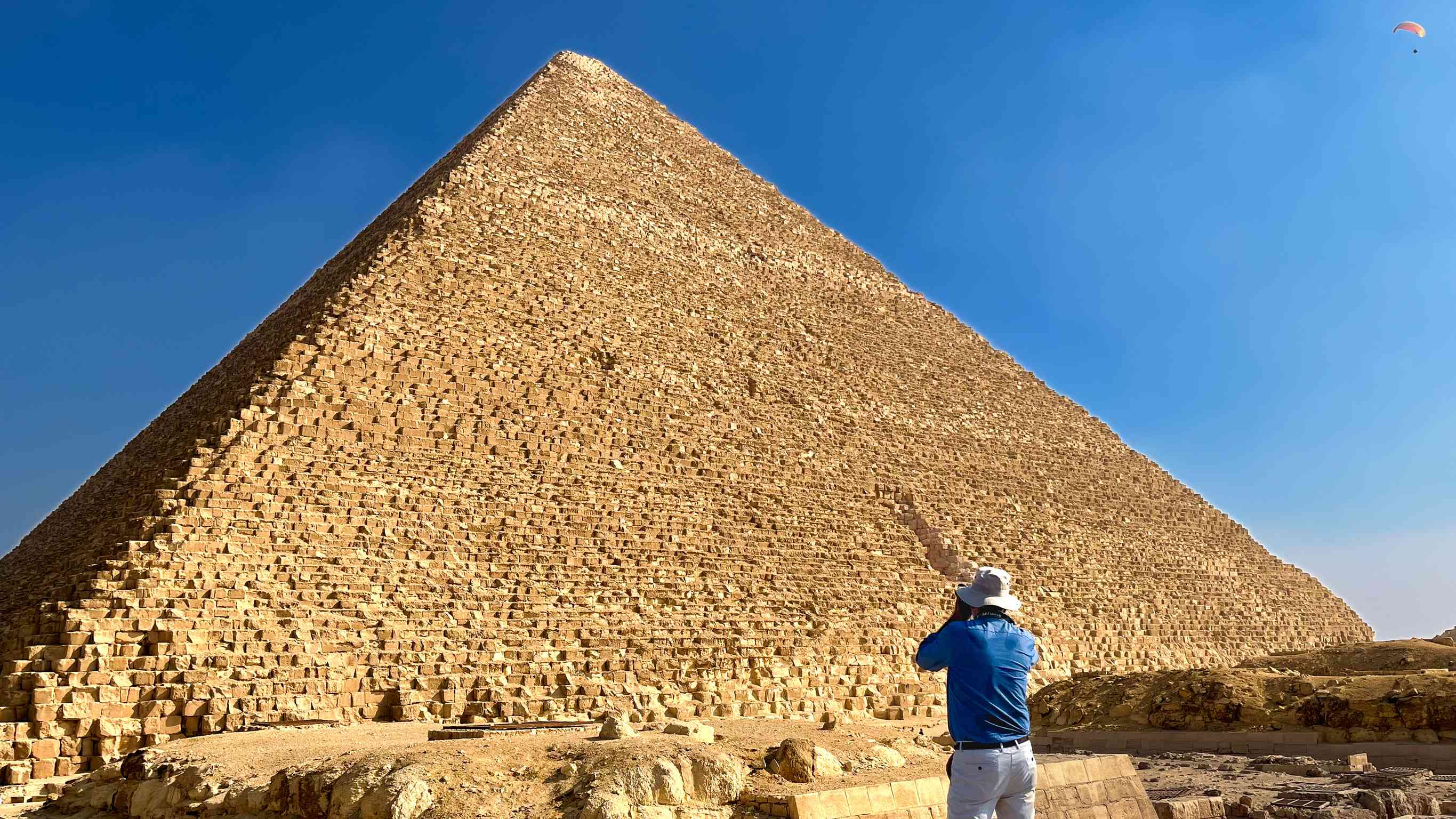 Tourist With Hat Photographing A Pyramid In Egypt With His Camera