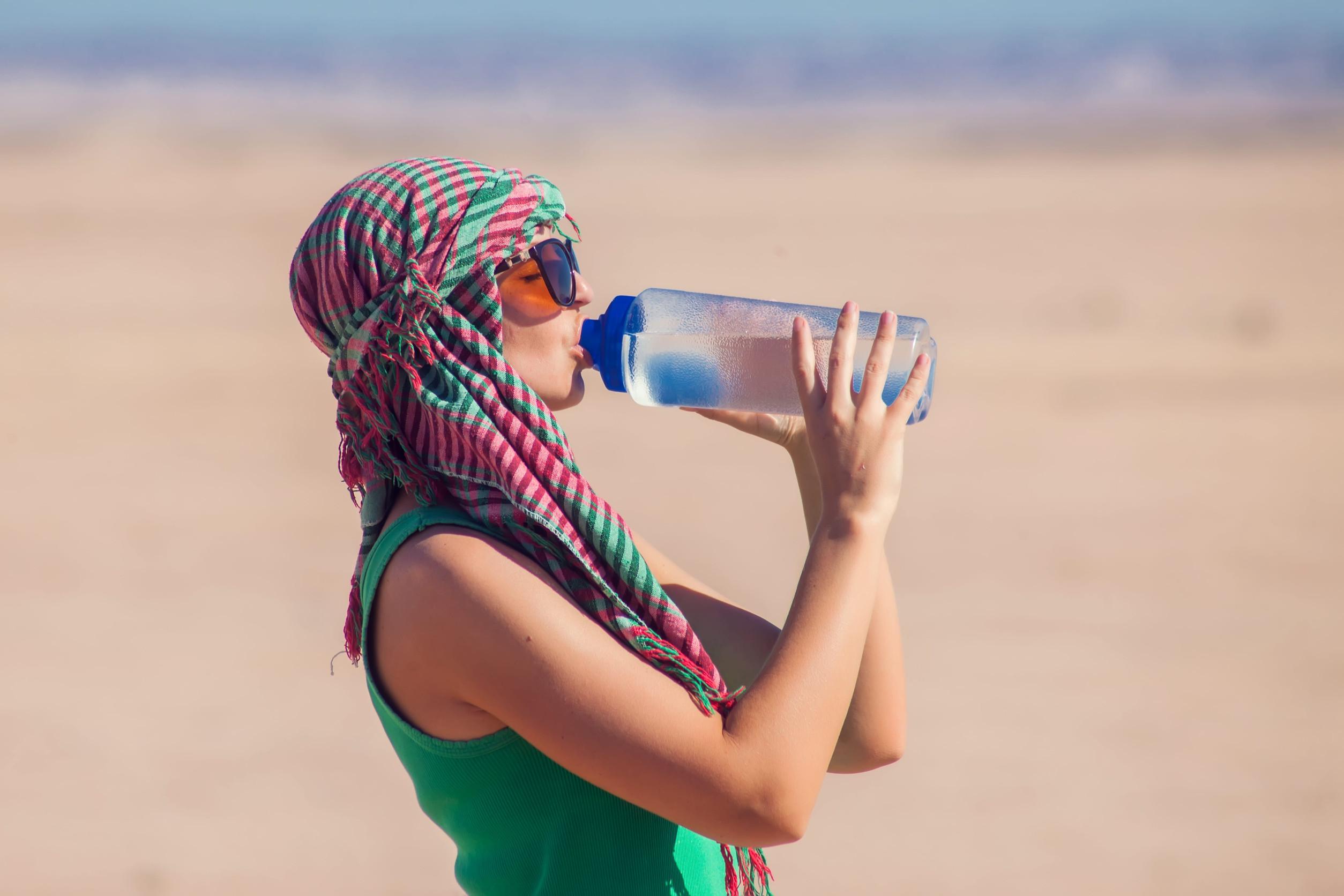 Woman drinking water in Egypt’s desert Woman drinking water in Egypt’s desert