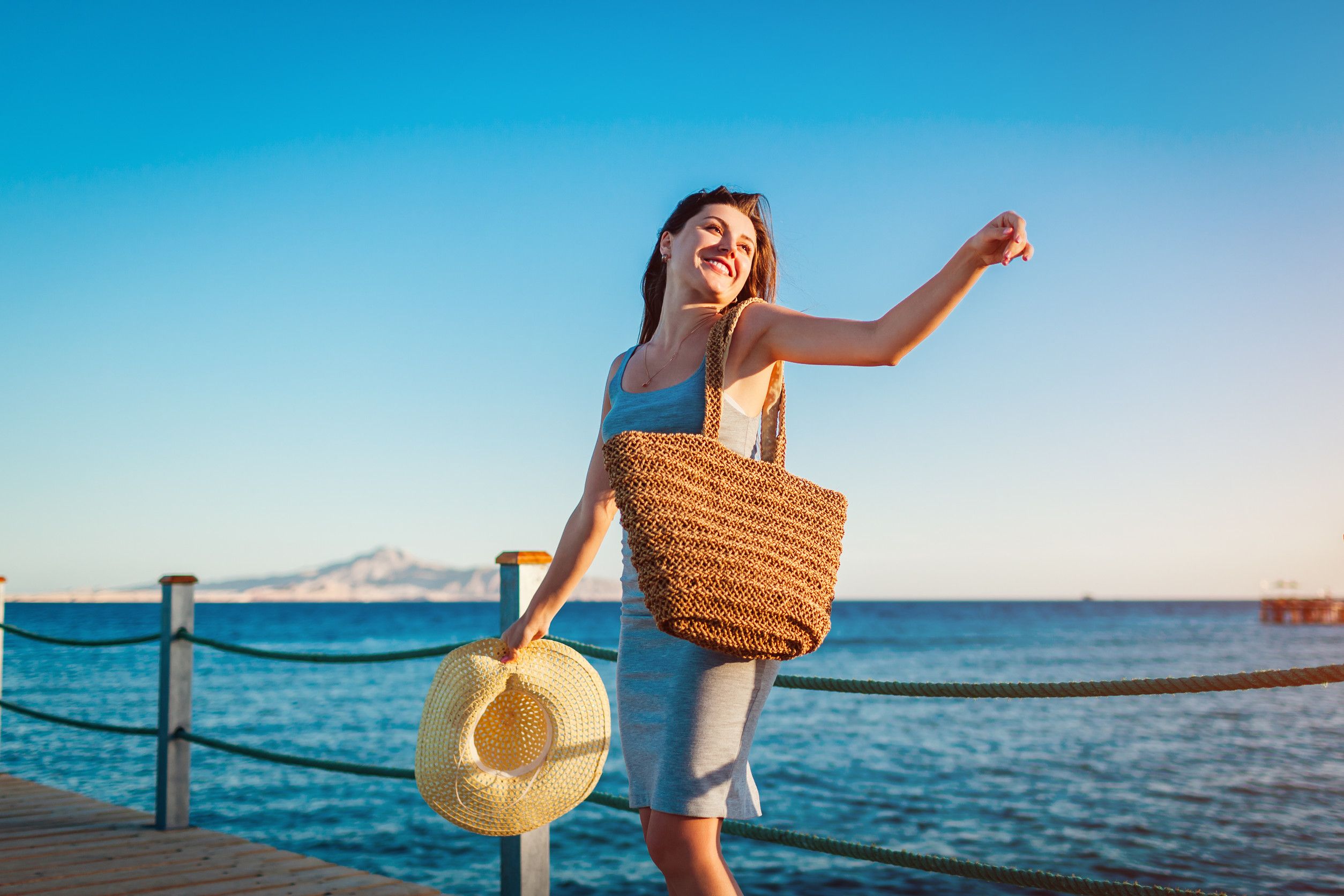 Young Woman Traveler Opens Arms And Feeling Happy And Free On Pier By Red Sea Summer Vacat